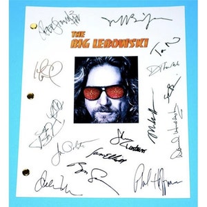May include: A white script with black signatures from the cast of the movie "The Big Lebowski". The signatures include Jeff Bridges, John Goodman, Steve Buscemi, Julianne Moore, Philip Seymour Hoffman, and others. A photo of Jeff Bridges as "The Dude" is in the center of the script.