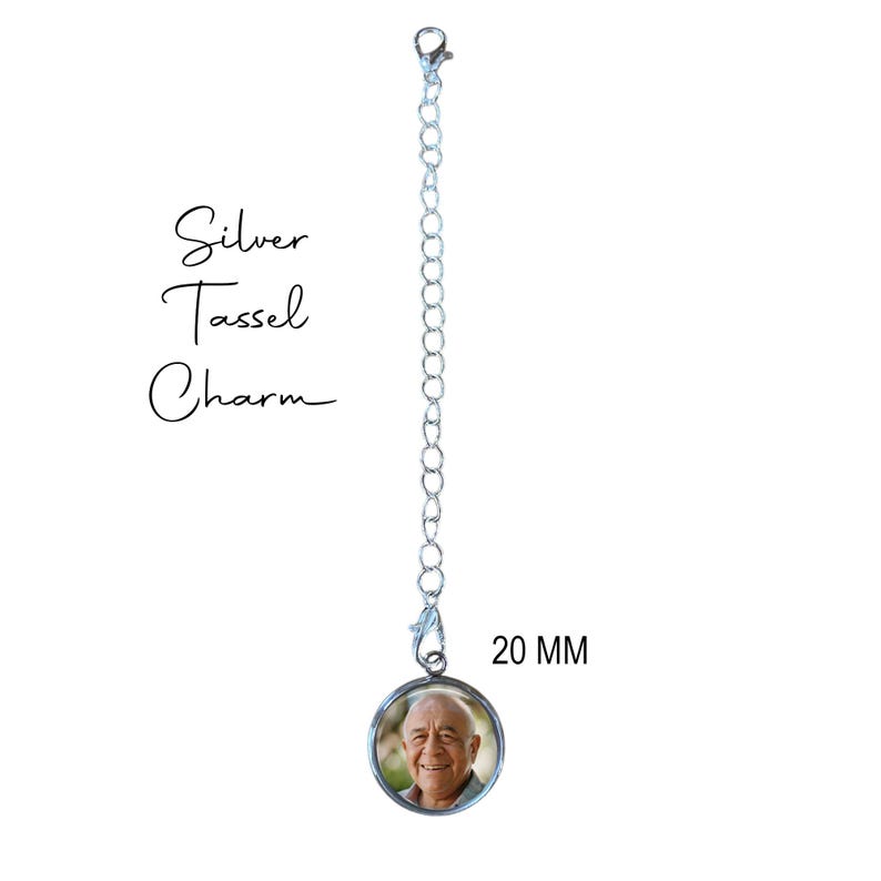 May include: A silver chain with a 20 mm round photo charm. The charm has a picture of a man with a white beard and a smile. The chain has a lobster clasp.