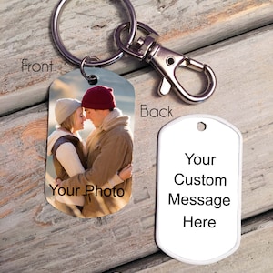 May include: A personalized metal keychain with a photo on the front and space for a custom message on the back. The front displays a couple embracing, with the text "Your Photo". The back has the text "Your Custom Message Here".