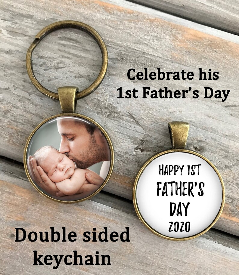 May include: Double-sided keychain with a photo of a father kissing a baby on one side and the text "Happy 1st Father's Day 2020" on the other side.