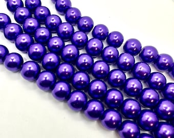May include: A strand of purple pearl beads. The beads are round and have a shiny, metallic finish.