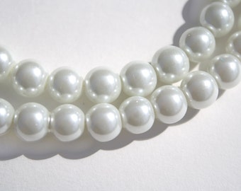 May include: A strand of white pearl beads, arranged in a double row, with a slight curve in the center.