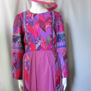 May include: A long, pink dress with a patchwork bodice featuring a variety of colors and patterns, including purple, red, and blue. The skirt is a solid pink.