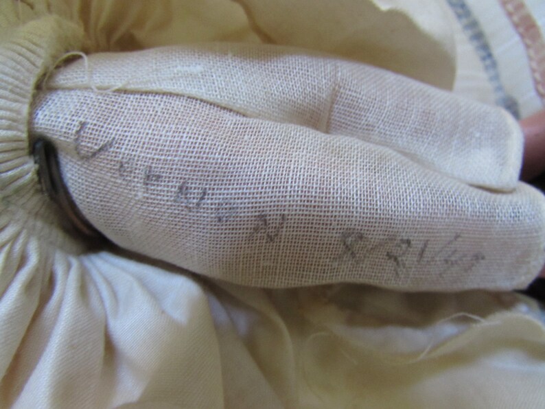 May include: Close-up of a white fabric with a fine mesh texture. The fabric has handwritten text on it, including the words "Unity" and "Peace".