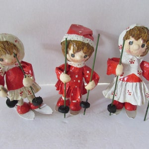 Holiday Decor Christmas Ornaments Paper Mache Trio Ski Figurines Red White Red Dots Brown Hair Green Poles Norwegian Style Swiss Style