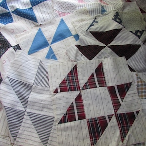 Könnte beinhalten: Eine Sammlung quadratischer Stoff-Quiltblöcke mit verschiedenen geometrischen Mustern und Farben. Die Blöcke zeigen Designs mit rot-schwarzem Schottenmuster, blauen Dreiecken und dunklen Blumenmustern auf weißem Grund mit Streifen und Punkten.