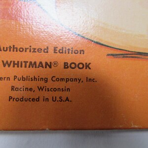 May include: Close-up of a book cover with text. The text reads "Authorized Edition A WHITMAN BOOK" and "Western Publishing Company, Inc. Racine, Wisconsin Produced in U.S.A." The background is orange.