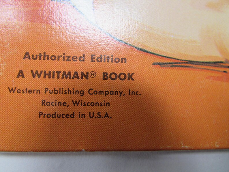 May include: Close-up of a book cover with text. The text reads "Authorized Edition A WHITMAN BOOK" and "Western Publishing Company, Inc. Racine, Wisconsin Produced in U.S.A." The background is orange.