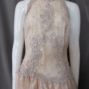 May include: A delicate, off-white lace dress with a high neckline and a fitted bodice. The dress features intricate floral lace patterns and a flowing skirt.