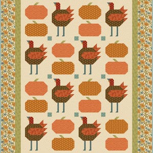 Puede incluir: Un edredón de retazos con un patrón repetido de pavos y calabazas en tonos naranja, marrón y crema. El edredón tiene un borde floral en naranja, azul y verde, creando un tema otoñal cálido.