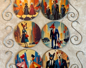 Puede incluir: Seis adornos redondos de madera con imágenes de perros en diferentes entornos. Los adornos están decorados con ilustraciones coloridas de perros con diferentes atuendos y poses, incluyendo un perro con traje y corbata, un perro con vestido y un perro paseando a un perro más pequeño. Los adornos tienen un gancho plateado para colgar.