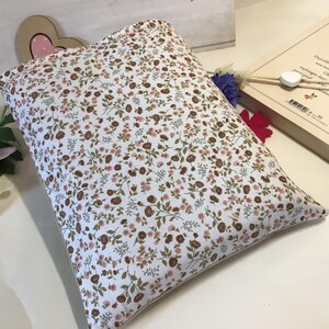 May include: A white pillowcase with a brown and pink floral pattern. The pillowcase is made of a soft, comfortable fabric and has a subtle sheen.