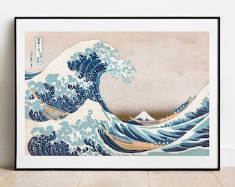 Op de afbeelding: Een ingelijste kunstdruk van de iconische houtsnede De Grote Golf bij Kanagawa. De afbeelding toont een torenhoge donkerblauwe golf met witte schuimkoppen, drie houten boten met roeiers en de berg Fuji in de verte, geplaatst in een zwarte lijst.