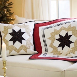 Może przedstawiać: Dwie dekoracyjne poduszki z wzorem gwiazdy w kolorze beżowym, czarnym i białym. Poduszki znajdują się na białej sofie z czerwoną i czarną kratą.