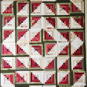 Peut inclure: Une courtepointe rouge, blanche et verte avec un motif de cabane en rondins. La courtepointe est compos&eacute;e de nombreux petits carr&eacute;s, chacun avec un motif diff&eacute;rent. La courtepointe est un design traditionnel et serait un excellent ajout &agrave; n'importe quelle maison.