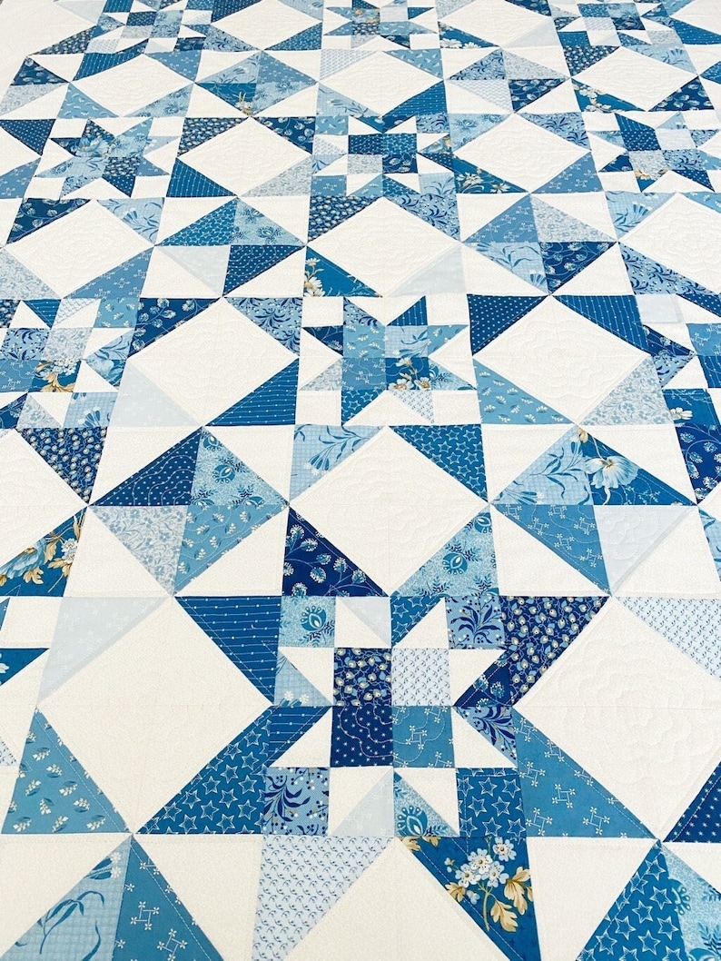 Peut inclure: Une courtepointe avec un fond blanc et un motif d'&eacute;toiles et de carr&eacute;s bleus.