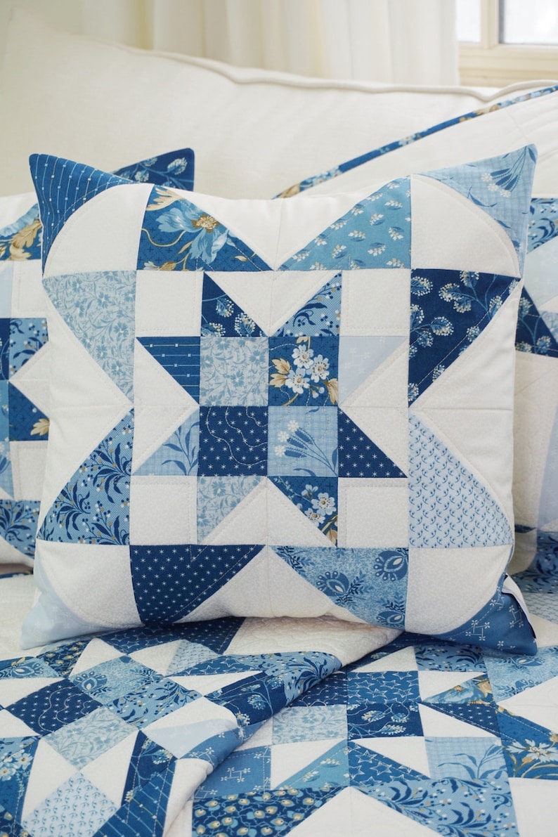 Peut inclure: Un oreiller bleu et blanc en patchwork avec un motif d'&eacute;toile. L'oreiller est fait de diff&eacute;rents tissus avec des motifs floraux et g&eacute;om&eacute;triques.