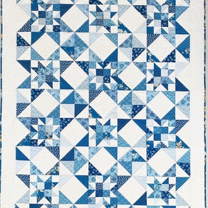 Peut inclure: Une courtepointe blanche avec un motif g&eacute;om&eacute;trique bleu et blanc. La courtepointe est compos&eacute;e de carr&eacute;s et de triangles et pr&eacute;sente un motif d'&eacute;toiles r&eacute;p&eacute;t&eacute;.