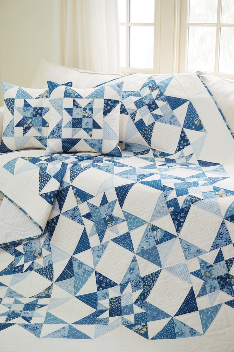Peut inclure: Une couette blanche avec un motif d'&eacute;toiles bleu et blanc. La couette est sur un lit avec deux oreillers assortis bleu et blanc.
