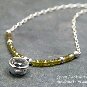 May include: A silver chain necklace with a round green amethyst pendant and green vesuvianite beads.