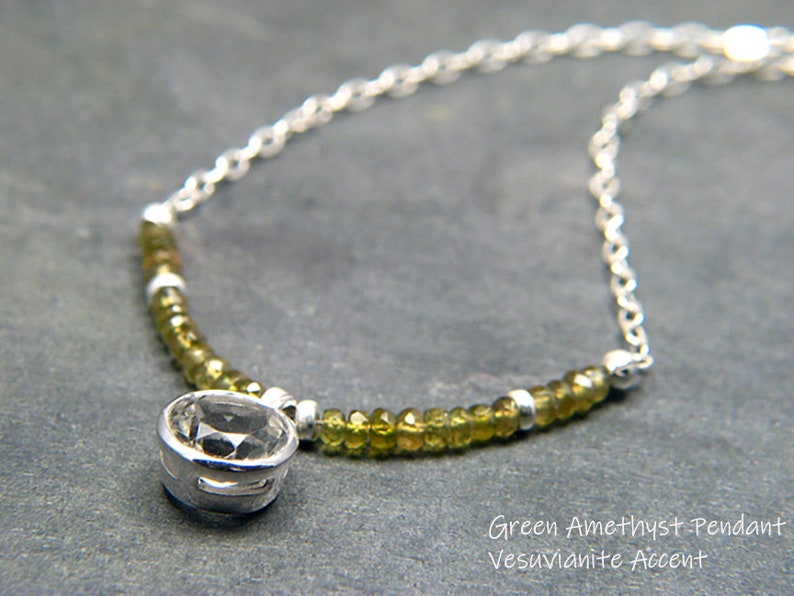 May include: A silver chain necklace with a round green amethyst pendant and green vesuvianite beads.