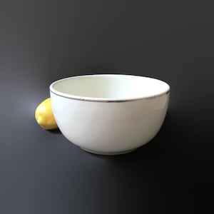 May include: A set of three ceramic mugs with a speckled, matte finish. Each mug features a different color: light blue, cream, and gray. The mugs have a simple, modern design with a rounded shape and a handle.