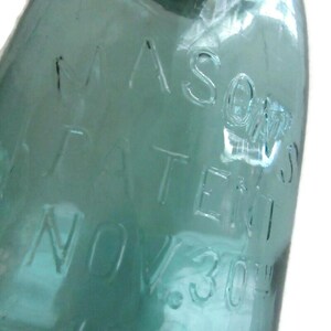 May include: A vintage green glass Mason jar with the text "MASON'S PATENT NOV 30 1858" embossed on the side.