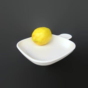 May include: A bright yellow lemon rests on a white, square-shaped serving dish with a handle. The dish has a smooth, glossy finish. The background is a solid black.