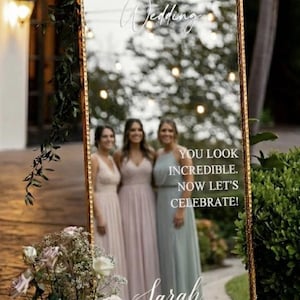 a mirror with a wedding invitation for a couple named Sarah and James. The mirror displays a photo of the couple and a message welcoming them to their wedding.