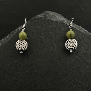 May include: Silver Celtic knot earrings with green stone beads.