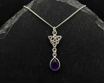 May include: A silver Celtic knot pendant necklace with a purple amethyst teardrop charm.