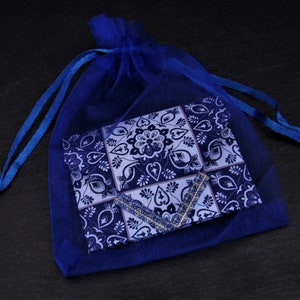 May include: A blue and white patterned fabric pouch in a blue mesh drawstring bag.