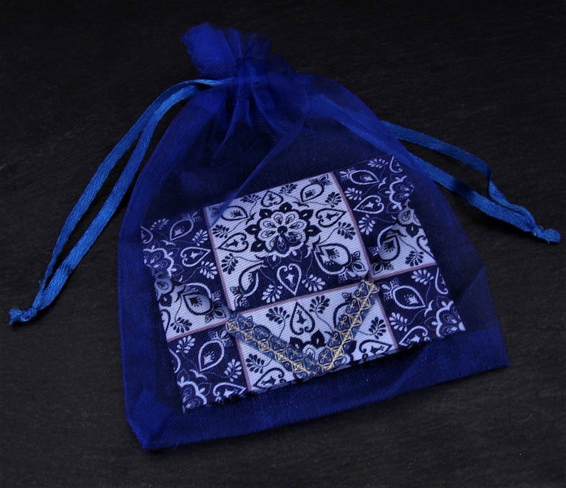 May include: A blue and white patterned fabric pouch in a blue mesh drawstring bag.