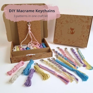 May include: A macrame keychain craft kit with the text "DIY Macrame Keychains" and "3 patterns in one craft kit". The kit includes a box, keychains, and colourful macrame cords in various colours like pink, blue, and yellow.