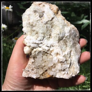 May include: A large, rough, white rock with a cluster of clear quartz crystals embedded in it.