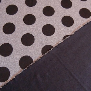 Könnte beinhalten: Nahaufnahme von zwei Stoffen. Der obere Stoff ist grau mit schwarzen Punkten. Der untere Stoff ist einfarbig dunkelgrau.