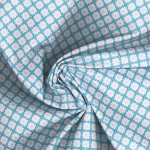 May include: White fabric with a repeating pattern of blue and pink star-shaped designs.