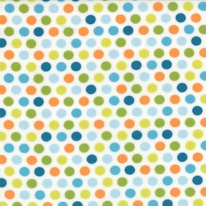 May include: White fabric with a repeating pattern of colorful polka dots. The dots are in shades of orange, green, blue, and yellow. The dots are evenly spaced across the fabric.