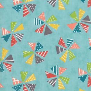 May include: A turquoise fabric with a repeating pattern of colorful pinwheel shapes. Each pinwheel features triangles in various colors, including red, yellow, green, and gray, with polka dots and stripes.