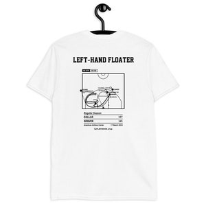 Pode incluir: Uma camiseta branca com um diagrama de jogo de basquete preto nas costas. O diagrama mostra um jogador de basquete driblando a bola e fazendo um arremesso de flutuador com a mão esquerda. O texto "LEFT-HAND FLOATER" está no topo do diagrama. O texto "Regular Season" está abaixo do diagrama. O texto "DALLAS 107" e "DENVER 105" está abaixo do texto "Regular Season". O texto "American Airlines Center 17 March 2024" está abaixo das pontuações. O texto "PLAYBOOK shop" está na parte inferior do diagrama.
