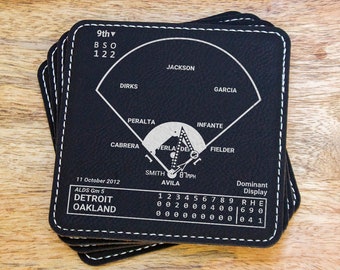 May include: A stack of black square coasters with white stitching. Each coaster features a baseball field diagram with player names and game statistics. The date "11 October 2012" is visible.