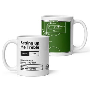 Può includere: Una tazza in ceramica bianca con un grafico di campo da calcio verde e il testo "Setting up the Treble" e "Giggs 109'" sul davanti. Il grafico mostra il punteggio della semifinale di FA Cup tra Arsenal e Manchester United, 1-2.