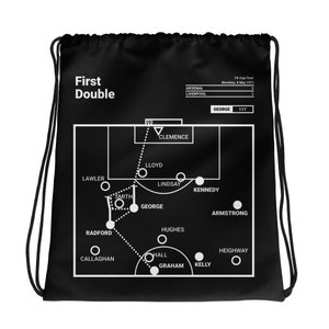 Puede incluir: Bolsa de cordón negro y blanco con un diseño de campo de fútbol. El diseño muestra la alineación de la final de la FA Cup de 1971 entre Arsenal y Liverpool. El texto "First Double" está en la parte superior de la bolsa.