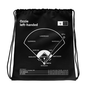 Puede incluir: Bolsa de cordón negra con un gráfico de campo de béisbol blanco y estadísticas del juego. El texto "Ozzie left-handed" está en la parte superior de la bolsa. Las estadísticas del juego muestran el marcador del Juego 5 de la NLCS entre los Dodgers de Los Ángeles y los Cardenales de San Luis el 14 de octubre de 1985.