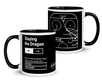 May include: A white ceramic mug with a black rim and handle. The mug features a black and white hockey game play diagram with the text "Slaying the Dragon" and "OT 5:22". The text "Western Conference Quarters: Game 7 Rogers Arena, 26 Apr 2011" is also included. The mug is a great way to show your team spirit.