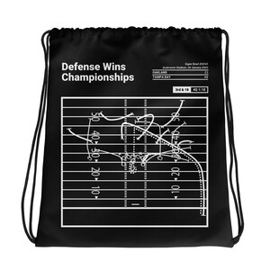 Puede incluir: Mochila negra con cordón de ajuste con un diagrama de juego de fútbol blanco y el texto "Defense Wins Championships" y "Super Bowl XXXVII, Qualcomm Stadium, 26 January 2003, Oakland 21, Tampa Bay 48, 3rd & 18, 4Q 1:18".