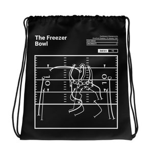 Puede incluir: Bolsa negra de cordón con un gráfico blanco de un diagrama de juego de fútbol americano. El texto "The Freezer Bowl" está en la parte superior de la bolsa. El texto "Conference Championship" está en la parte superior del diagrama. El texto "Riverfront Stadium, 10 January 1982" está debajo del texto "Conference Championship". El texto "SAN DIEGO 7" está en el lado izquierdo del diagrama. El texto "CINCINNATI 27" está en el lado derecho del diagrama. El texto "2nd & 6 1Q" está debajo del diagrama.