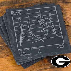 May include: Black slate coasters with a white football play diagram and text that reads "2Q 0:26 2nd & 10", "9 Jan 2023, Nat'l Championship", "3 TCU", "1 GEORGIA®", "7", "65", and "Back to back".