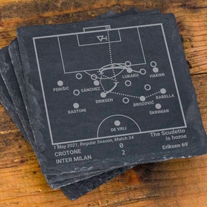 May include: A stack of square, dark gray slate coasters. Each coaster features a soccer field diagram with player names and game details: Crotone vs. Inter Milan, May 1, 2021. The text "The Scudetto is home" is also included.