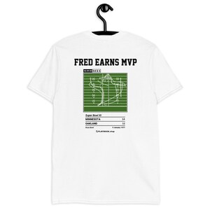 May include: White t-shirt with a green football play diagram and the text "FRED EARNS MVP" printed on the back. The diagram shows the play from Super Bowl XI, with the score of 14 to 32, and the date January 9, 1977.